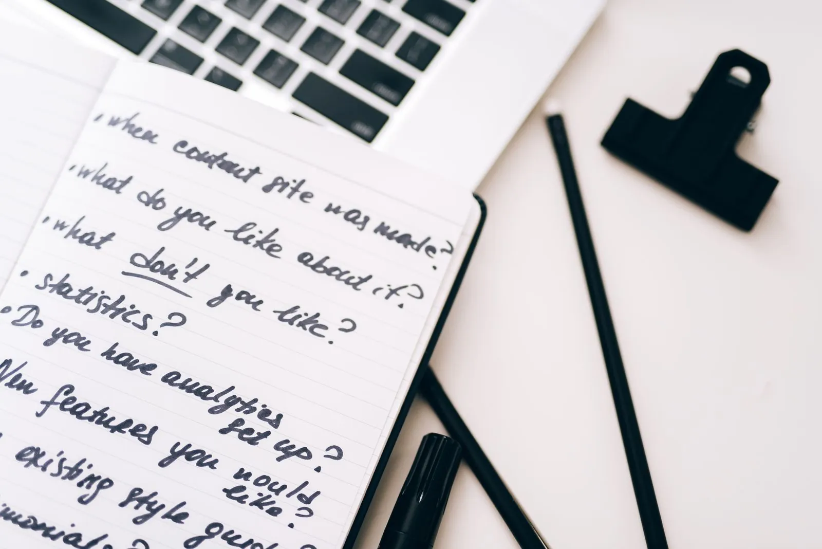 Handwritten content plan beside a laptop