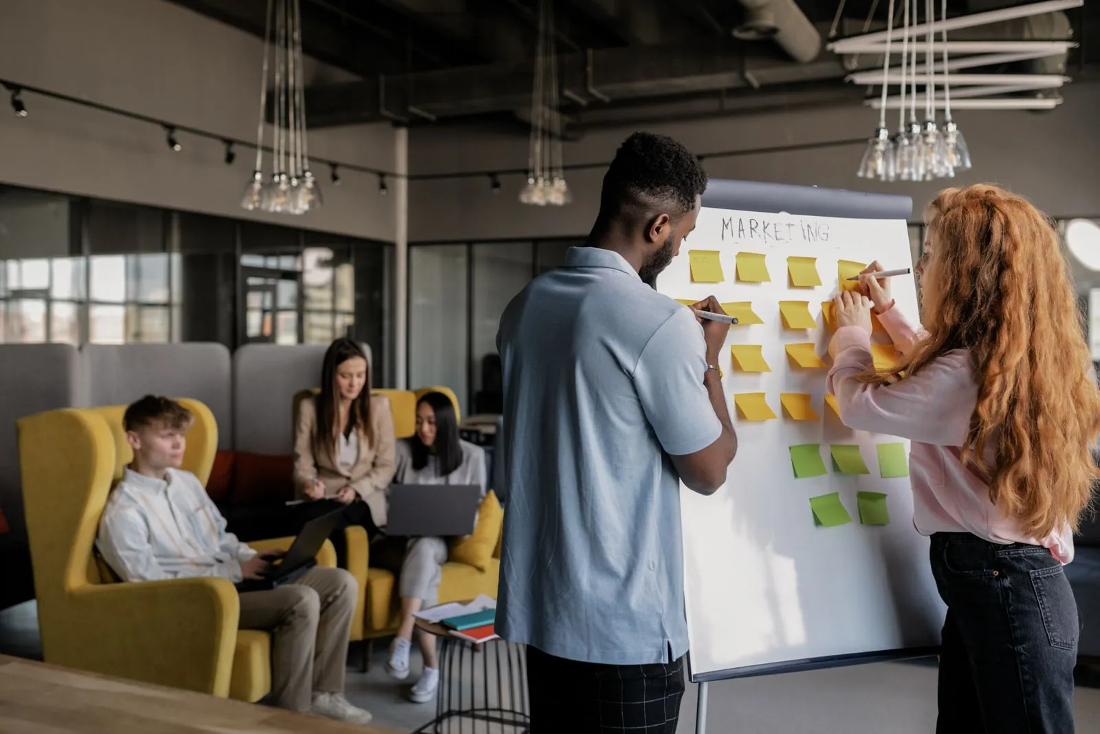 Marketing team planning a campaign on a whiteboard of sticky notes